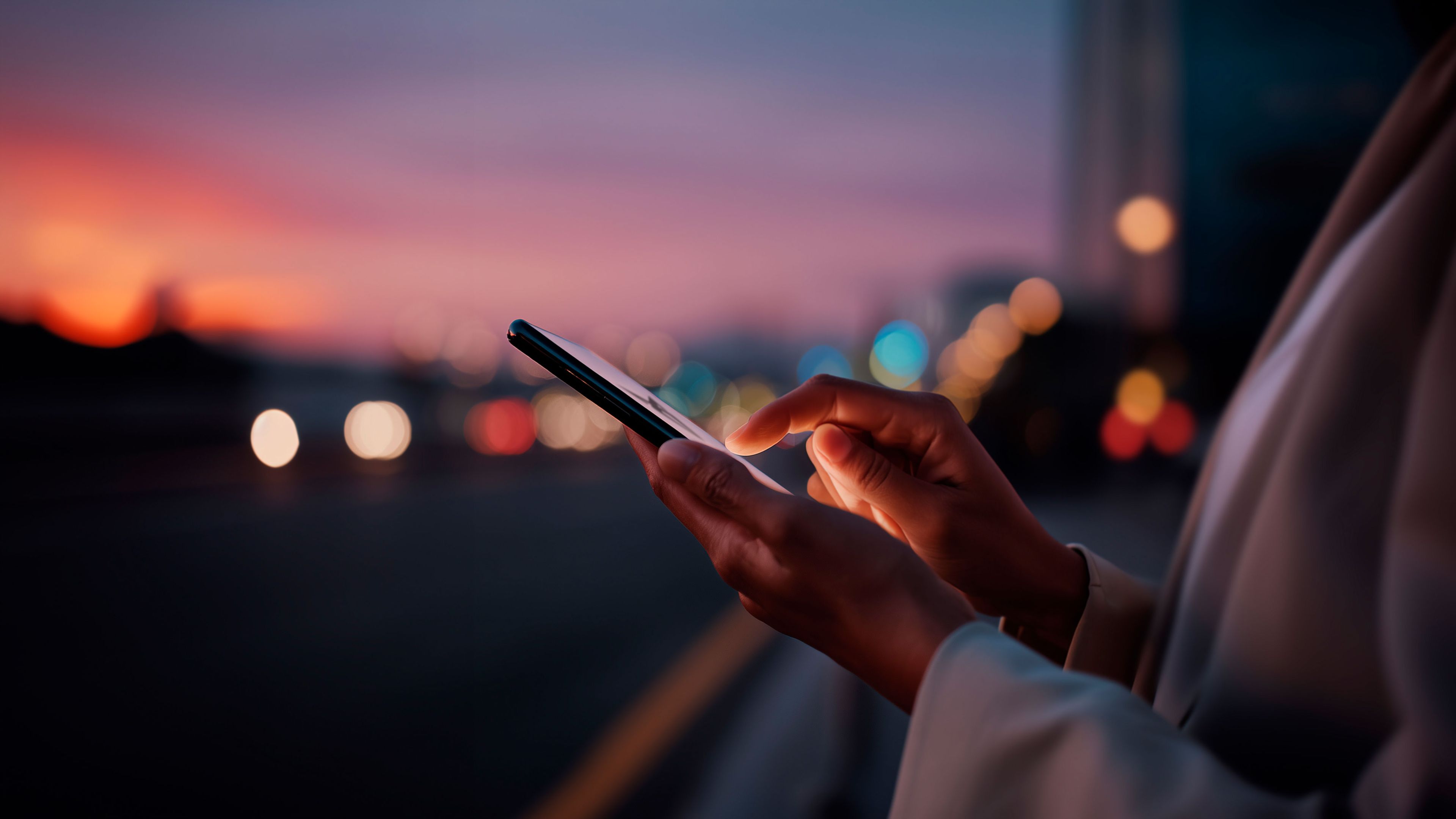 Človek drží svoj smartfón, aby ukázal, že si môže nastaviť vozidlo podľa svojich preferencií odkiaľkoľvek.