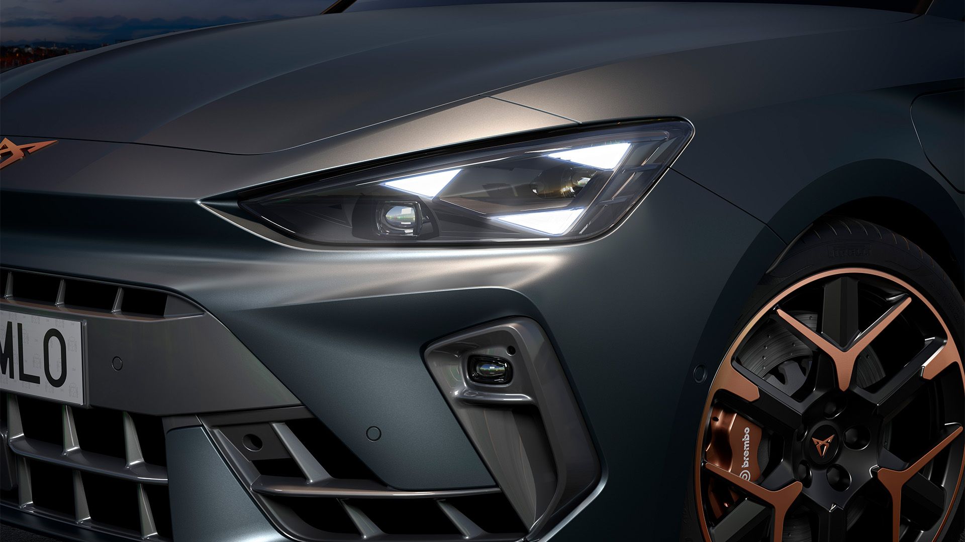 Detail na svetlomety a 19“ kované disky s medenými akcentmi a matnou karosériou v sivom lakovaní Enceladus nového hybridného vozidla CUPRA Leon 2024