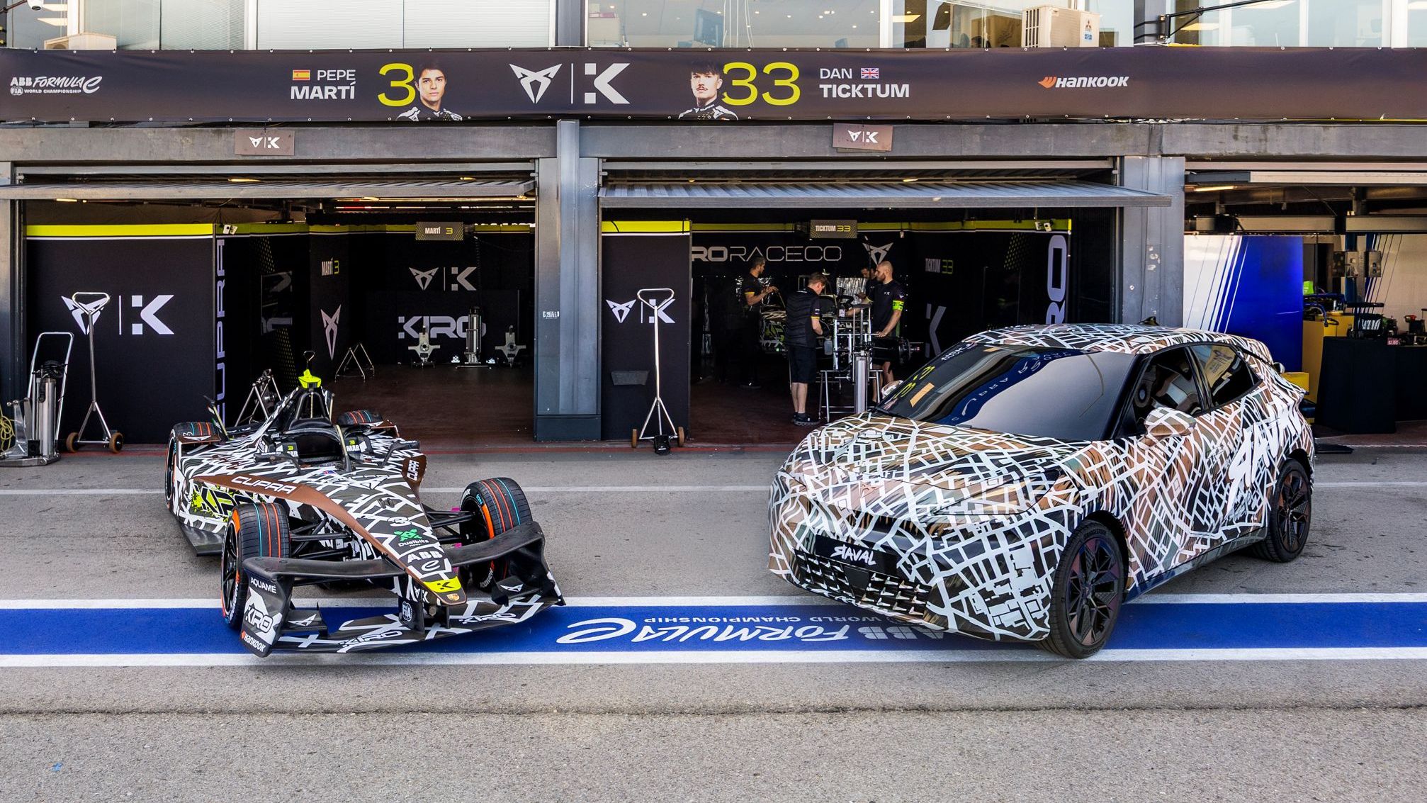 CUPRA Raval a Formula E zaparkované pred tímovými boxami. 