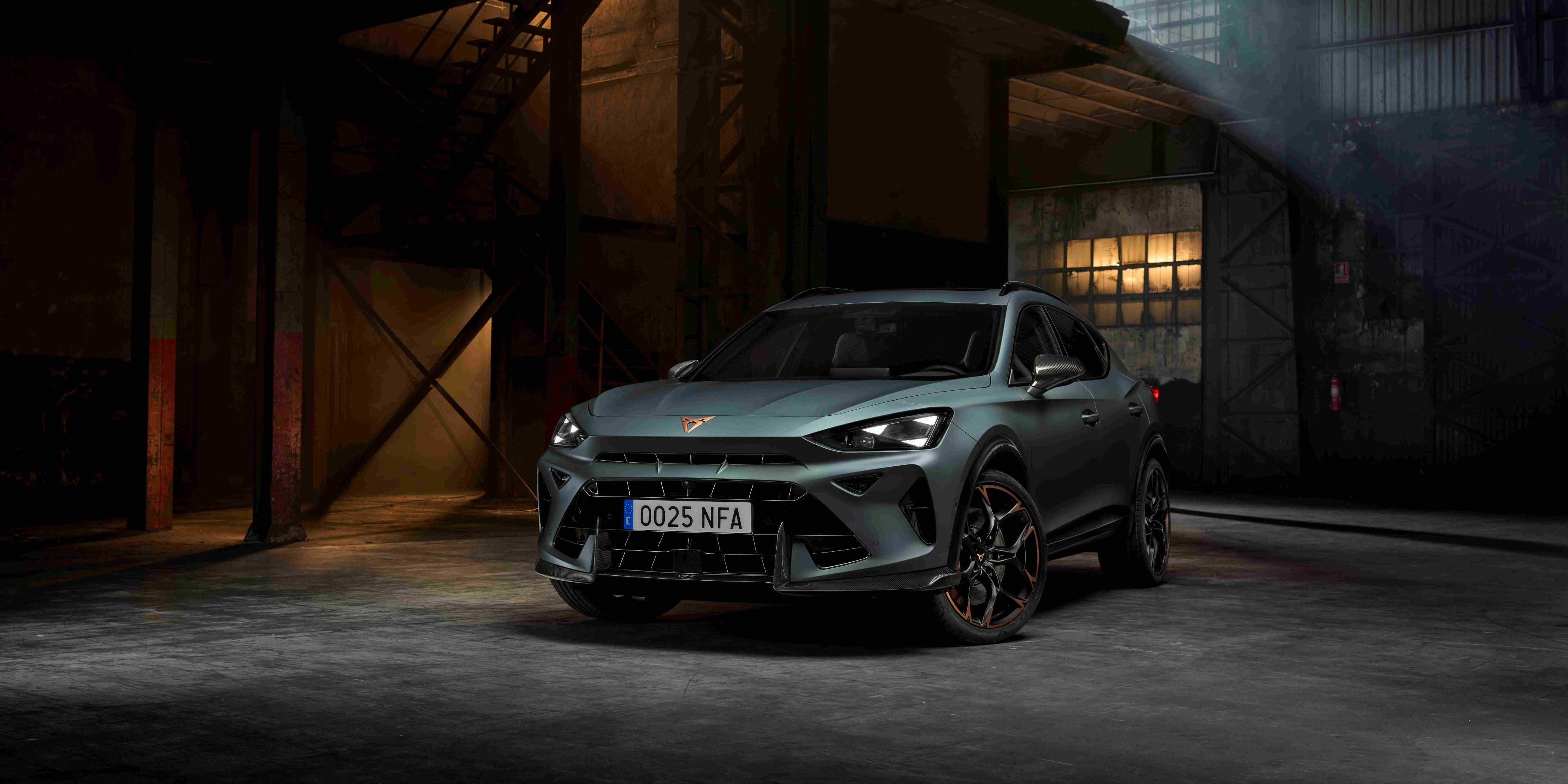 CUPRA Dormentor v zelenej farbe stojí v industriálnom prostredí s nepriamym osvetlením. Športový vzhľad auta podčiarkujú výrazné svetlá a aerodynamické línie. 