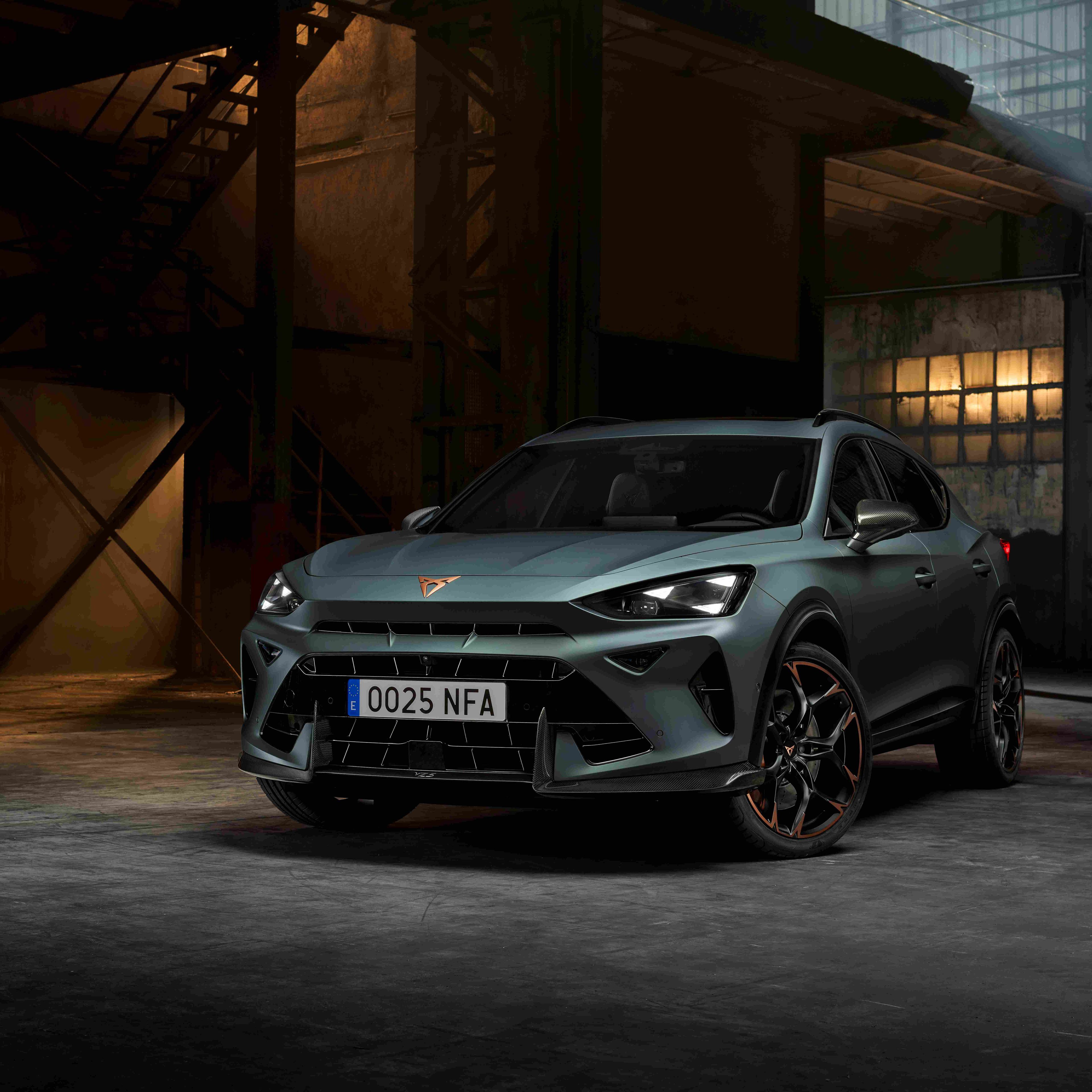 CUPRA Dormentor v zelenej farbe stojí v industriálnom prostredí s nepriamym osvetlením. Športový vzhľad auta podčiarkujú výrazné svetlá a aerodynamické línie. 