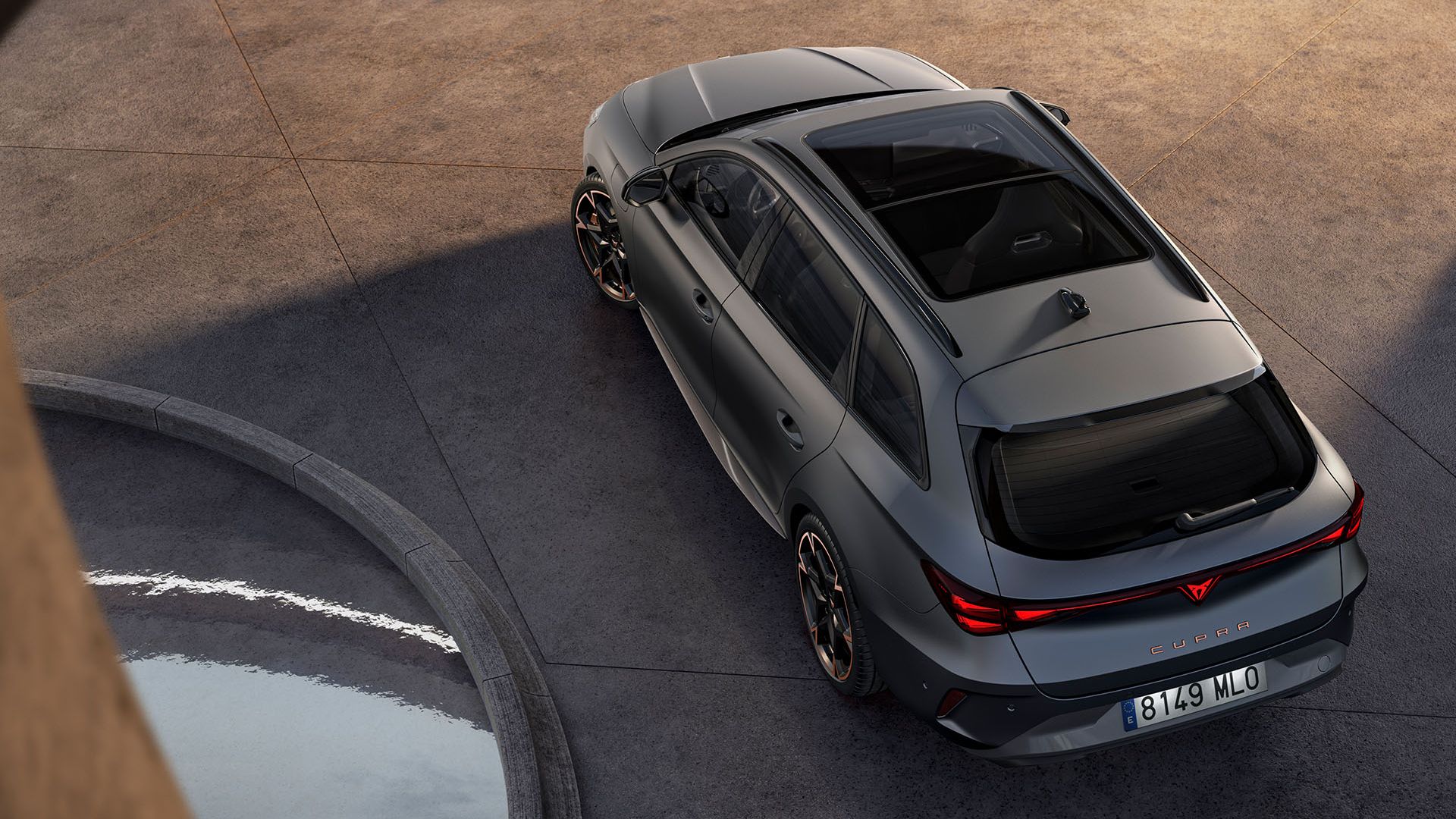 CUPRA Leon Sportstourer zaparkovaný pred sklenenou stenou modernej, futuristickej budovy.