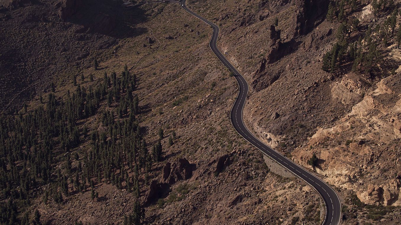 Úzka, kľukatá cesta vedie horskou krajinou so skalnatými svahmi a riedkymi stromami. Cesta sa zarezáva do svahu a serpentíny vytvárajú zaujímavý útvar. 