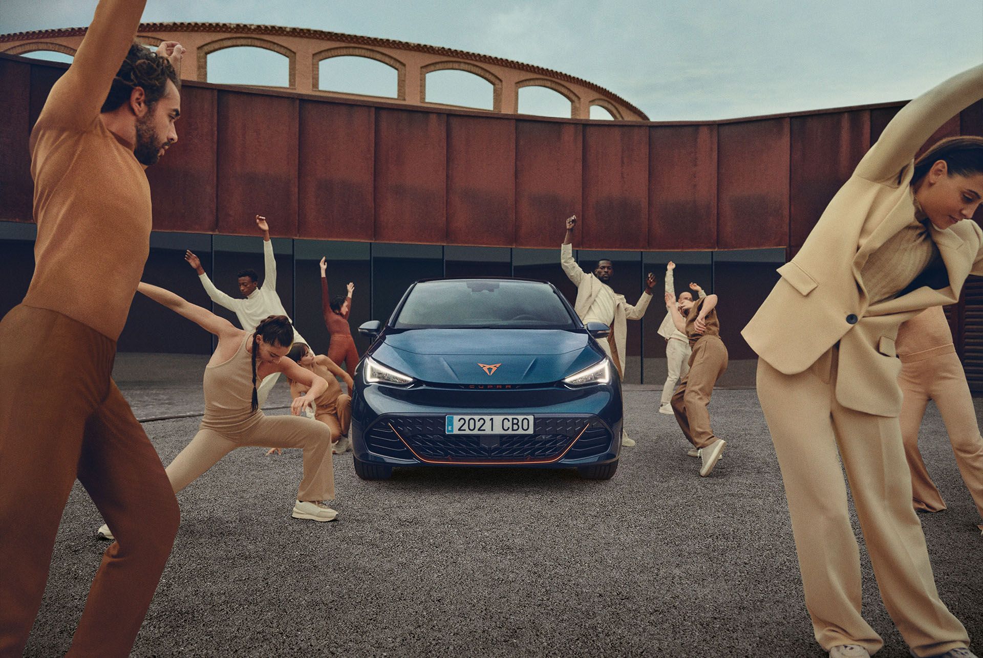 Ľudia pózujú pri zaparkovanom modeli CUPRA Born v modrom lakovaní Aurora