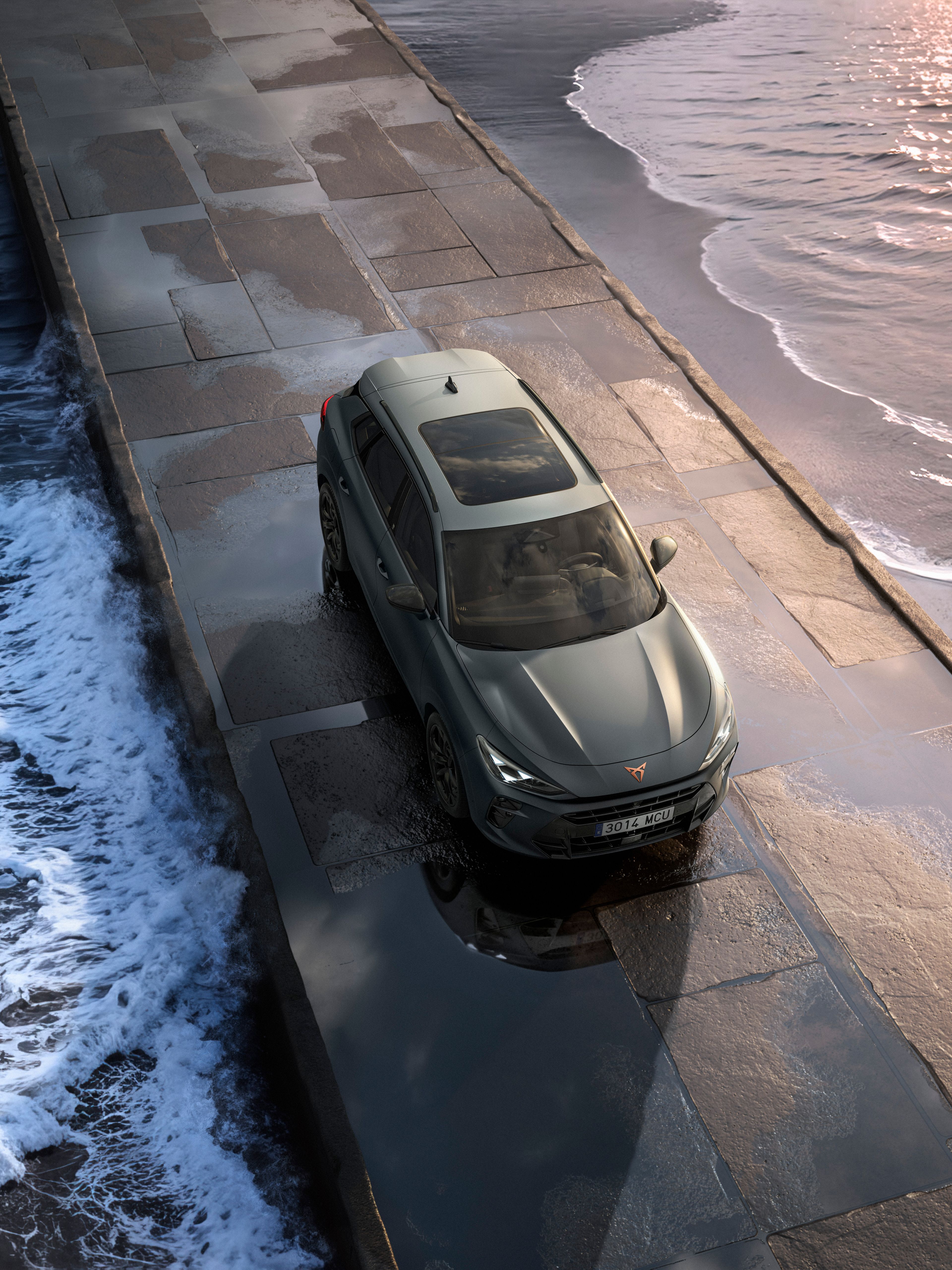 Auto jazdí po úzkom móle obklopenom rozbúreným morom. 