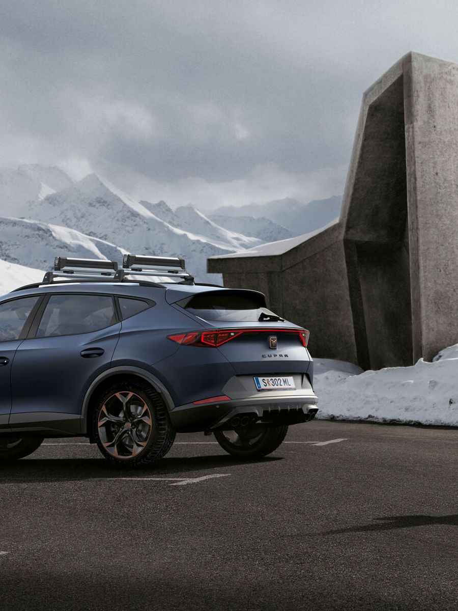 Ein CUPRA Formentor in blau, eine Frau steht davor
