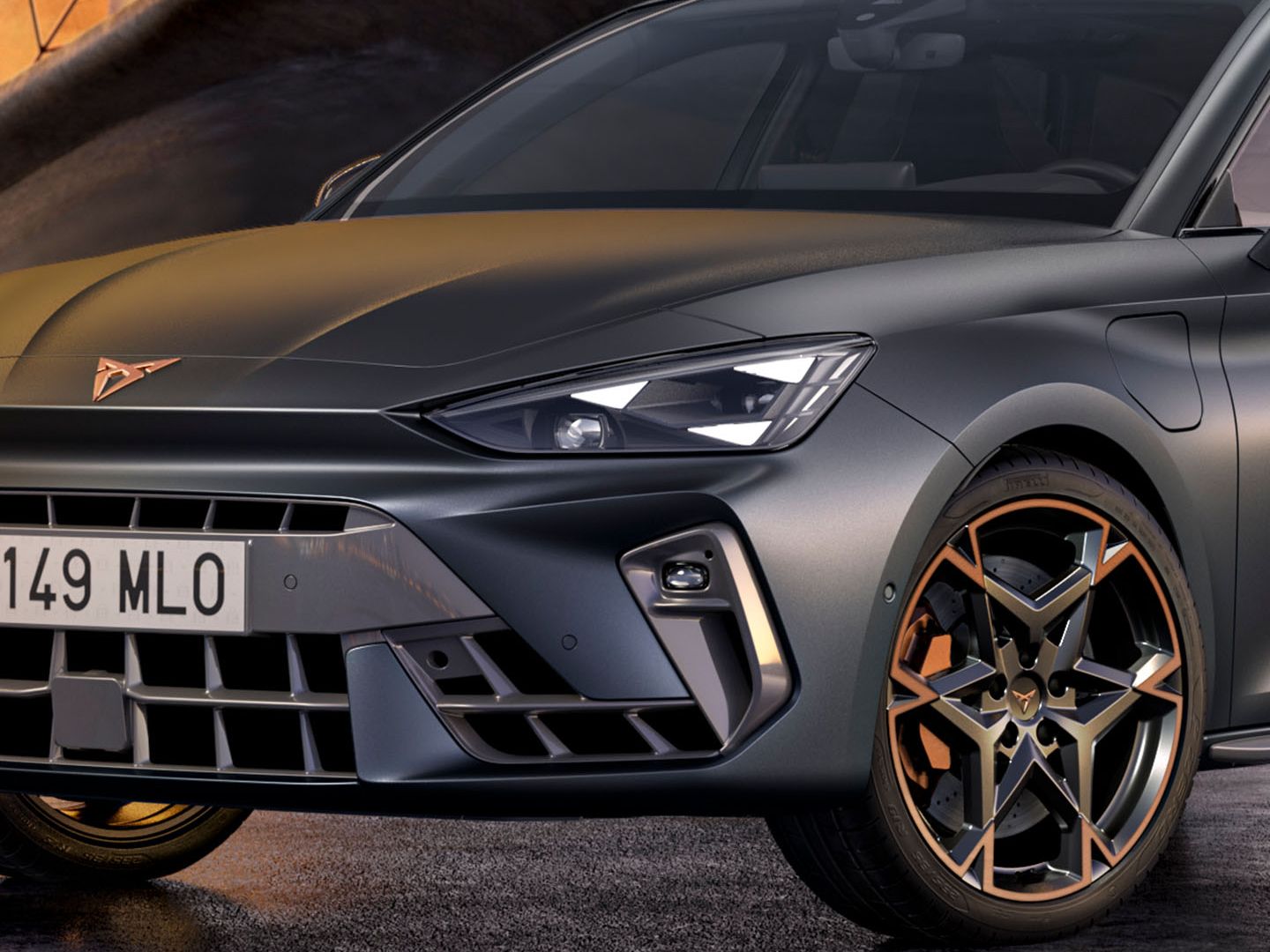 Predné partie tmavosivého športového auta značky CUPRA s výraznou maskou chladiča a nápadnými kolesami.