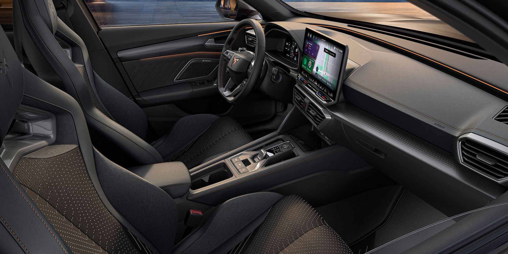 Pohľad do interiéru CUPRA Formentor 2024 so športovými sedadlami, detailným prešívaním, multifunkčným volantom, veľkými displejmi systému infotainment a elegantným dizajnom palubnej dosky. Z vozidla je cez čelné sklo výhľad na panorámu mesta za súmraku.