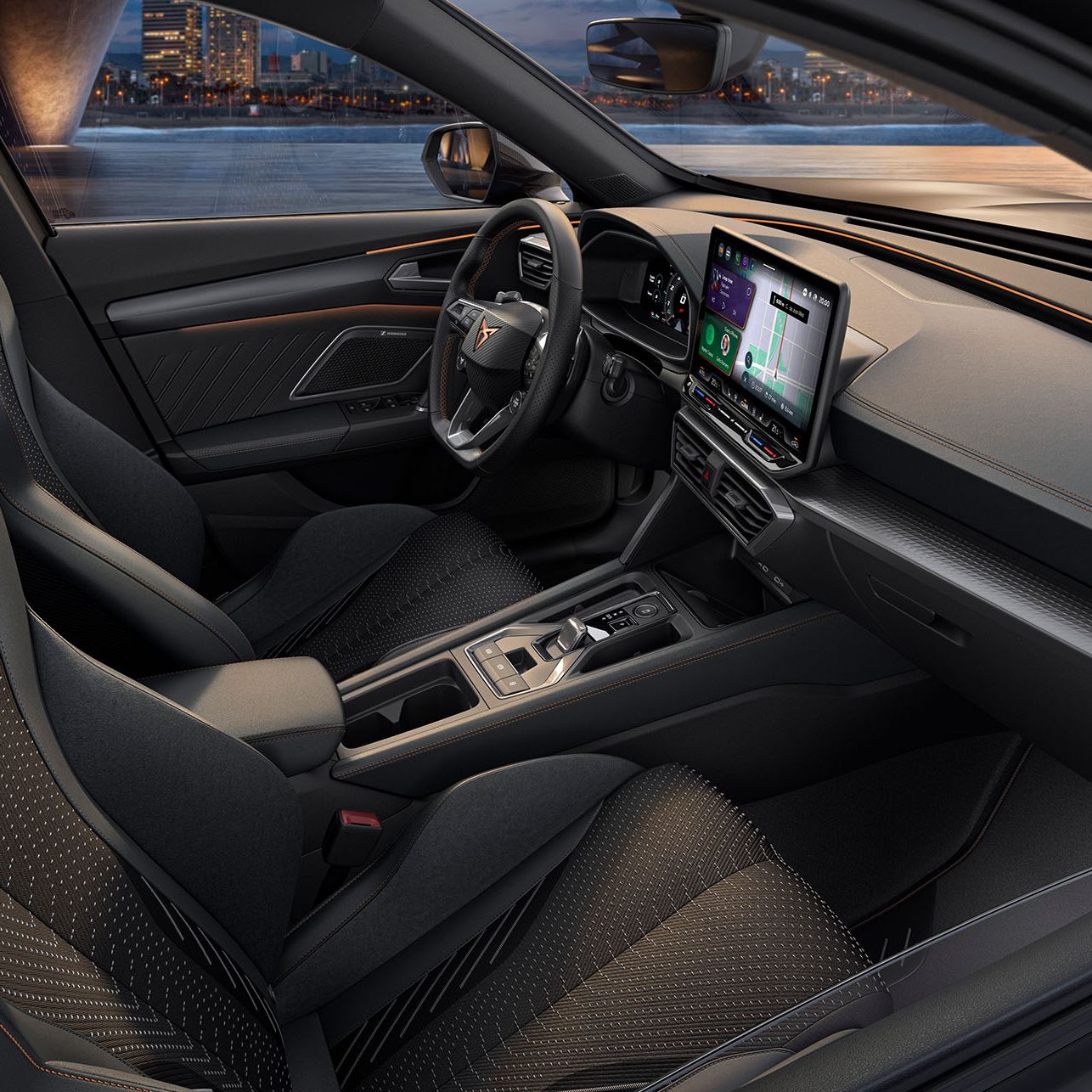 Pohľad do interiéru CUPRA Formentor 2024 so športovými sedadlami, detailným prešívaním, multifunkčným volantom, veľkými displejmi systému infotainment a elegantným dizajnom palubnej dosky. Z vozidla je cez čelné sklo výhľad na panorámu mesta za súmraku.