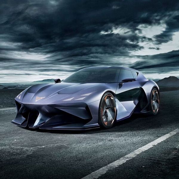 Štúdia vozidla CUPRA DarkRebel stojí na tmavej vozovke s horami v pozadí v temnom prítmí.