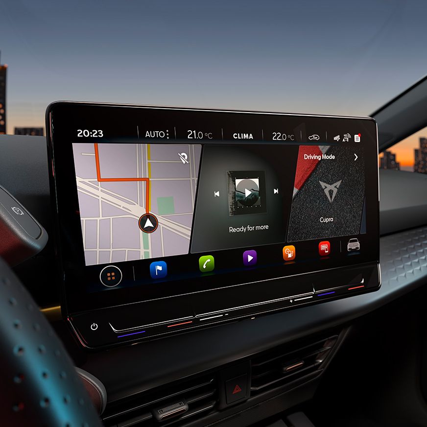 Digitálny displej systému infotainment v aute zobrazuje navigáciu a multimediálne ovládanie. V hornej časti informácia o počasí a teplote. Na obrazovke je vidieť mapu s trasou a ikony pre rôzne funkcie.