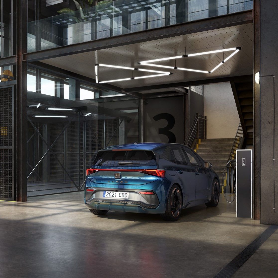 Modrý elektrický CUPRA Born je zaparkovaný v modernom parkovacom dome. Nabíja sa z nabíjacej stanice pri schodisku.