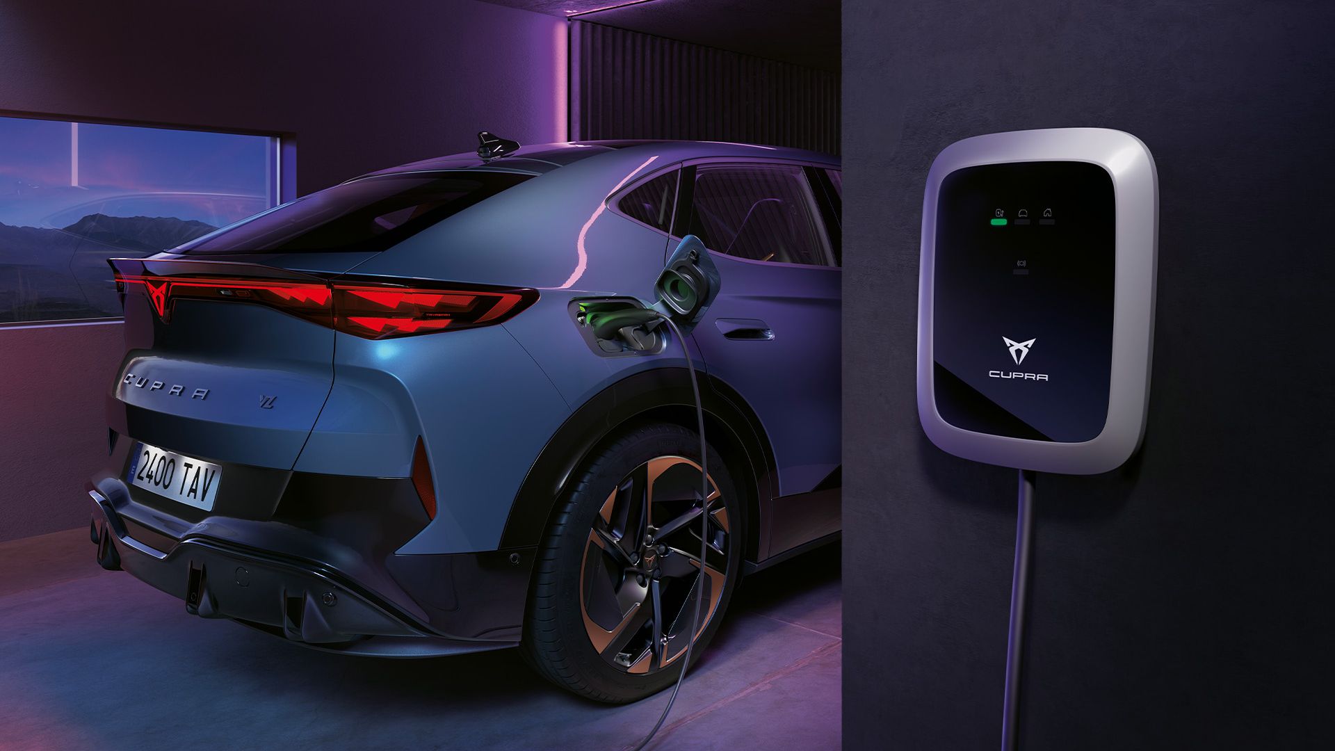 Modrý CUPRA Tavascan zaparkovaný v garáži sa nabíja prostredníctvom domácej nabíjacej stanice, ktorá je umiestnená na stene.