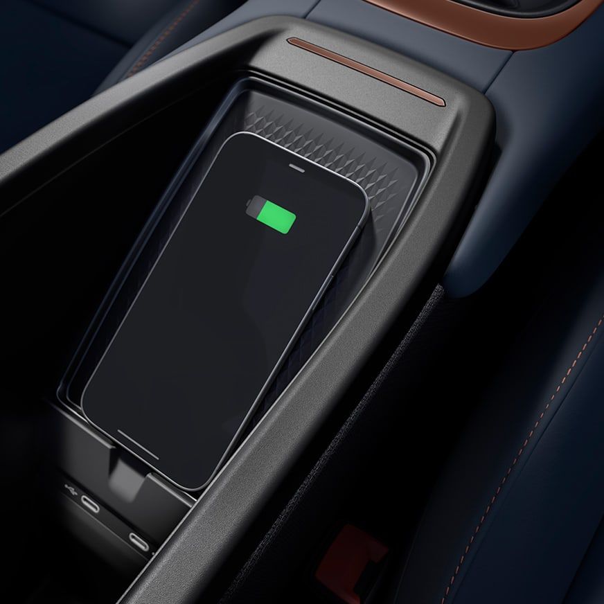 Mobilný telefón sa bezdrôtovo nabíja na nabíjacej stanici v aute. Na displeji telefónu svieti zelená ikona batérie. 