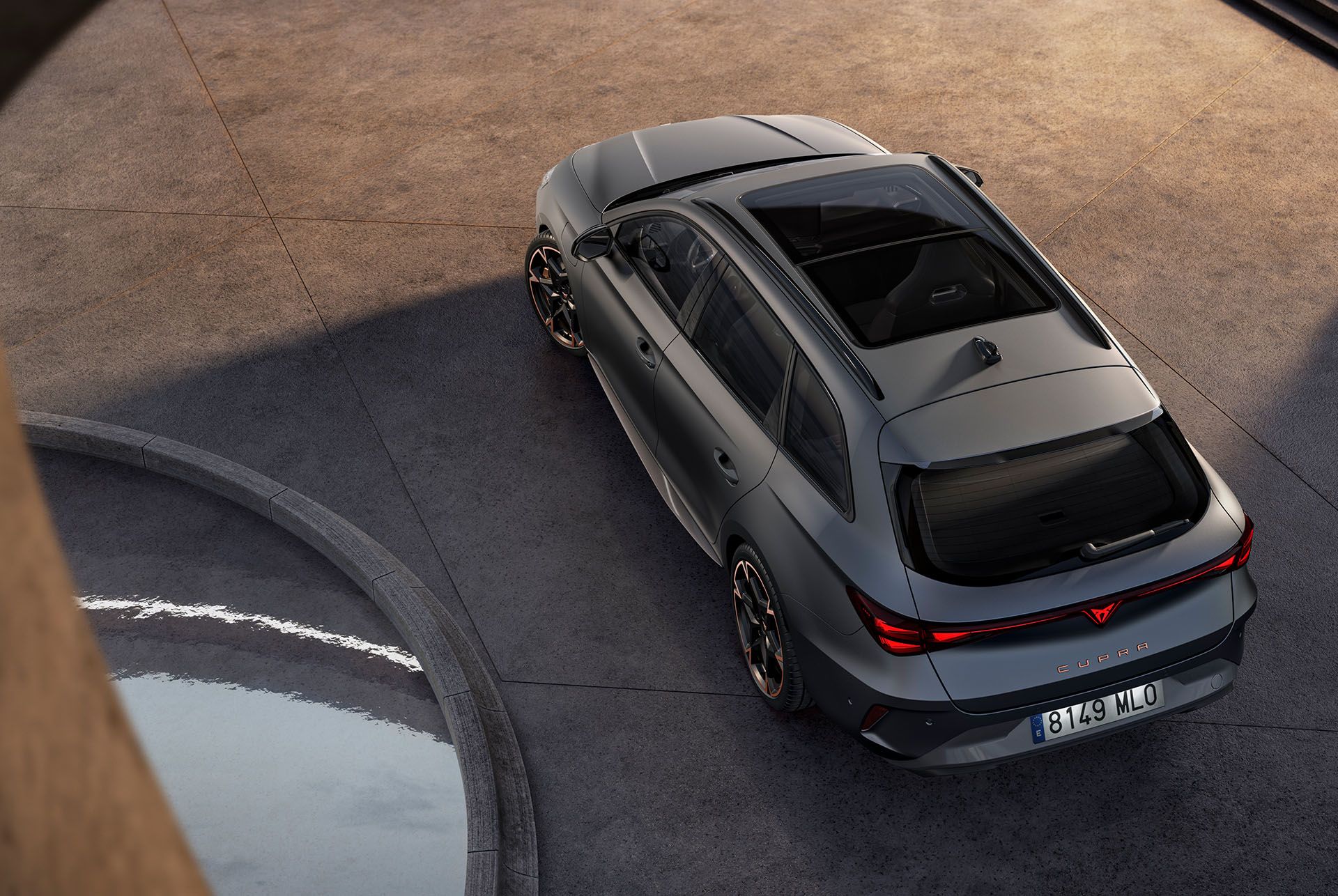 CUPRA Leon Sportstourer zaparkovaný pred sklenenou stenou modernej, futuristickej budovy.