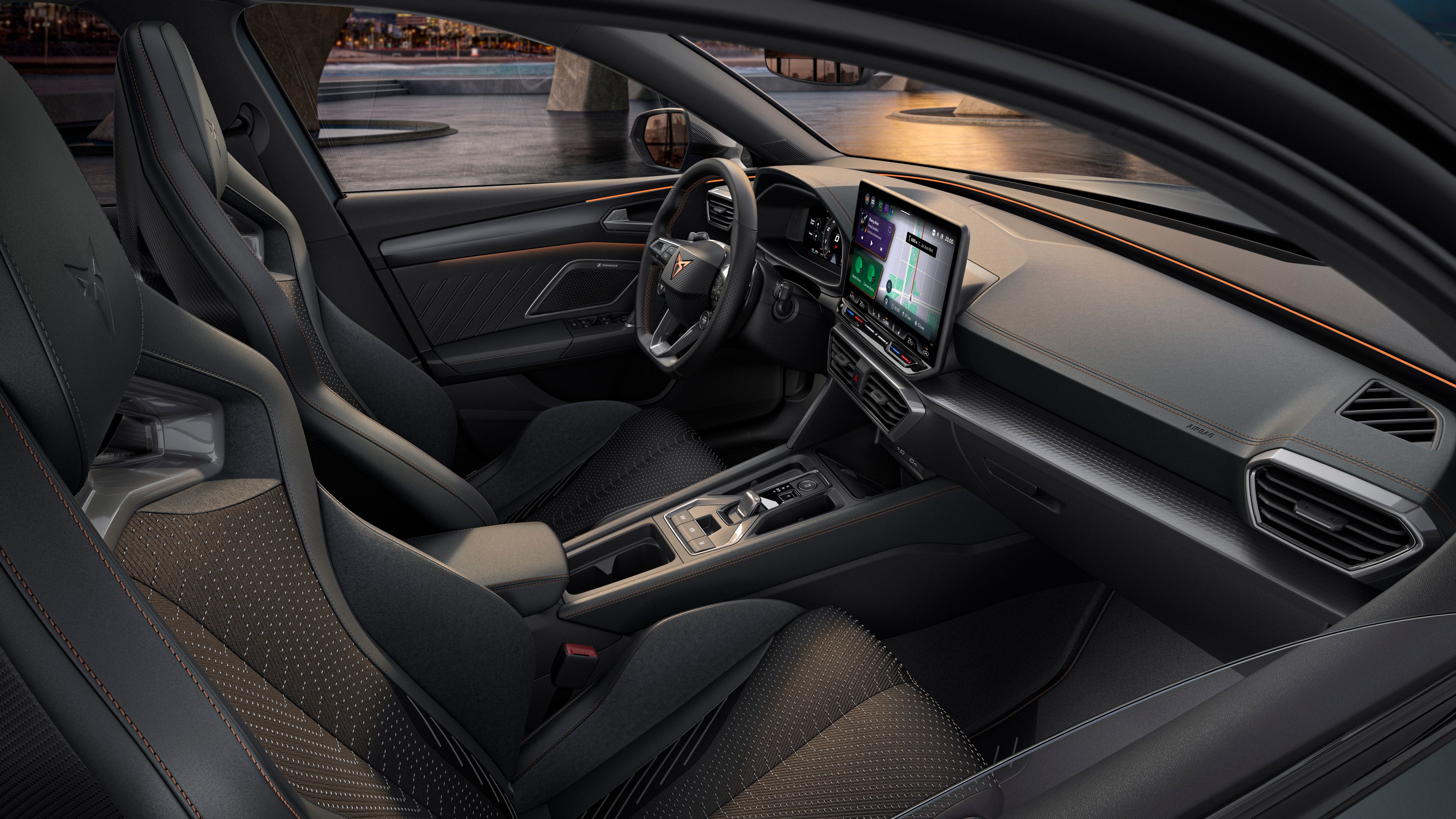 Luxusný interiér športového automobilu s modernou palubnou doskou, veľkým dotykovým displejom a vysoko kvalitnými sedadlami. Čierne sedadlá majú oranžové stehy. Do interiéru dopadá svetlo cez okná vozidla.