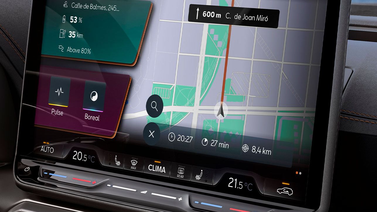 Detail na dotykový displej systému infotainment, ktorý zobrazuje mapu a navigačné pokyny. Sú zobrazené údaje o batérii a rôzne možnosti navigácie. V pozadí sa nachádza panoráma mesta, ktorú vidieť cez okno auta.