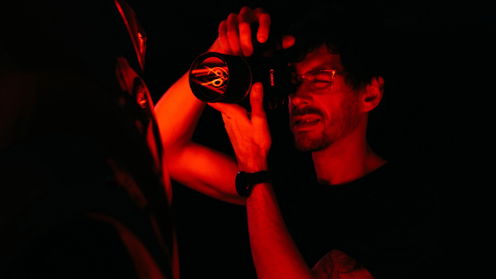 Fotograf fotí objekt za za červeného osvetlenia. 