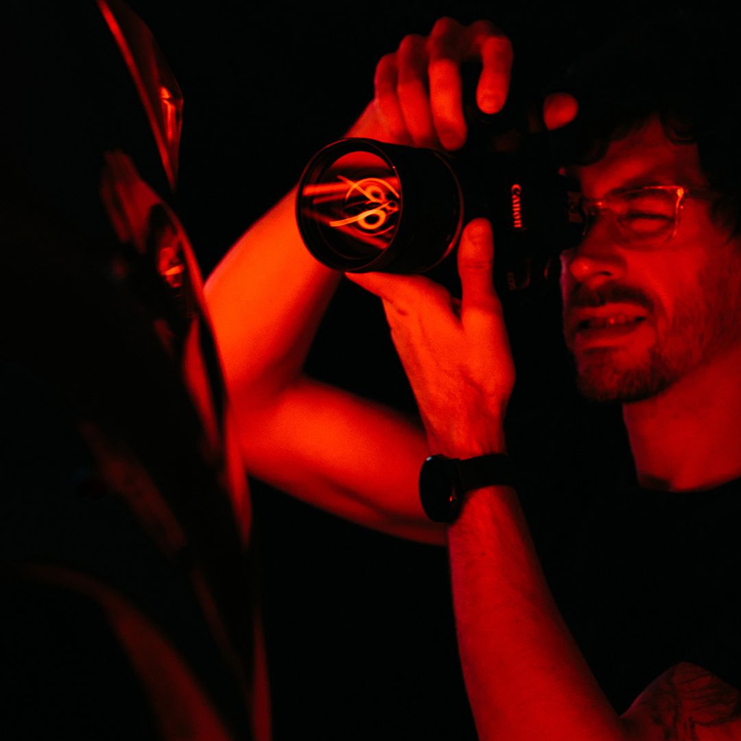 Fotograf fotí objekt za za červeného osvetlenia. 