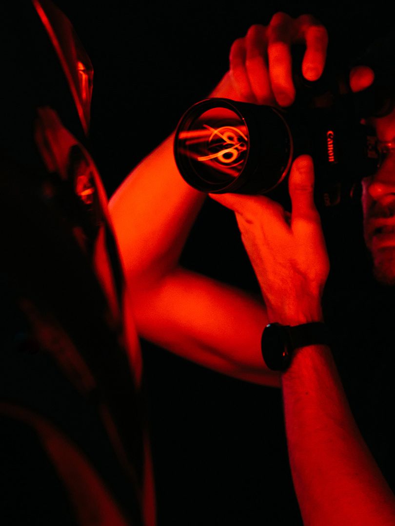 Fotograf fotí objekt za za červeného osvetlenia. 