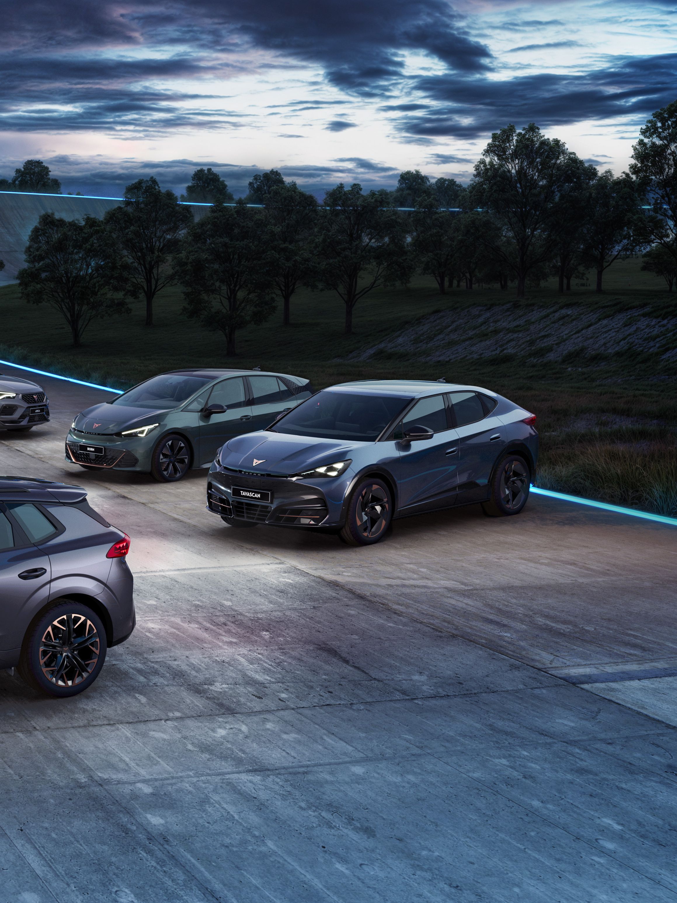 Pohľad na sedem športových vozidiel CUPRA , postavených na závodnej dráhe počas súmraku. Auta majú šedú farbu a sú to rôzne modely. Okolie je lemované stromami a osvetlené modrými svetlami.