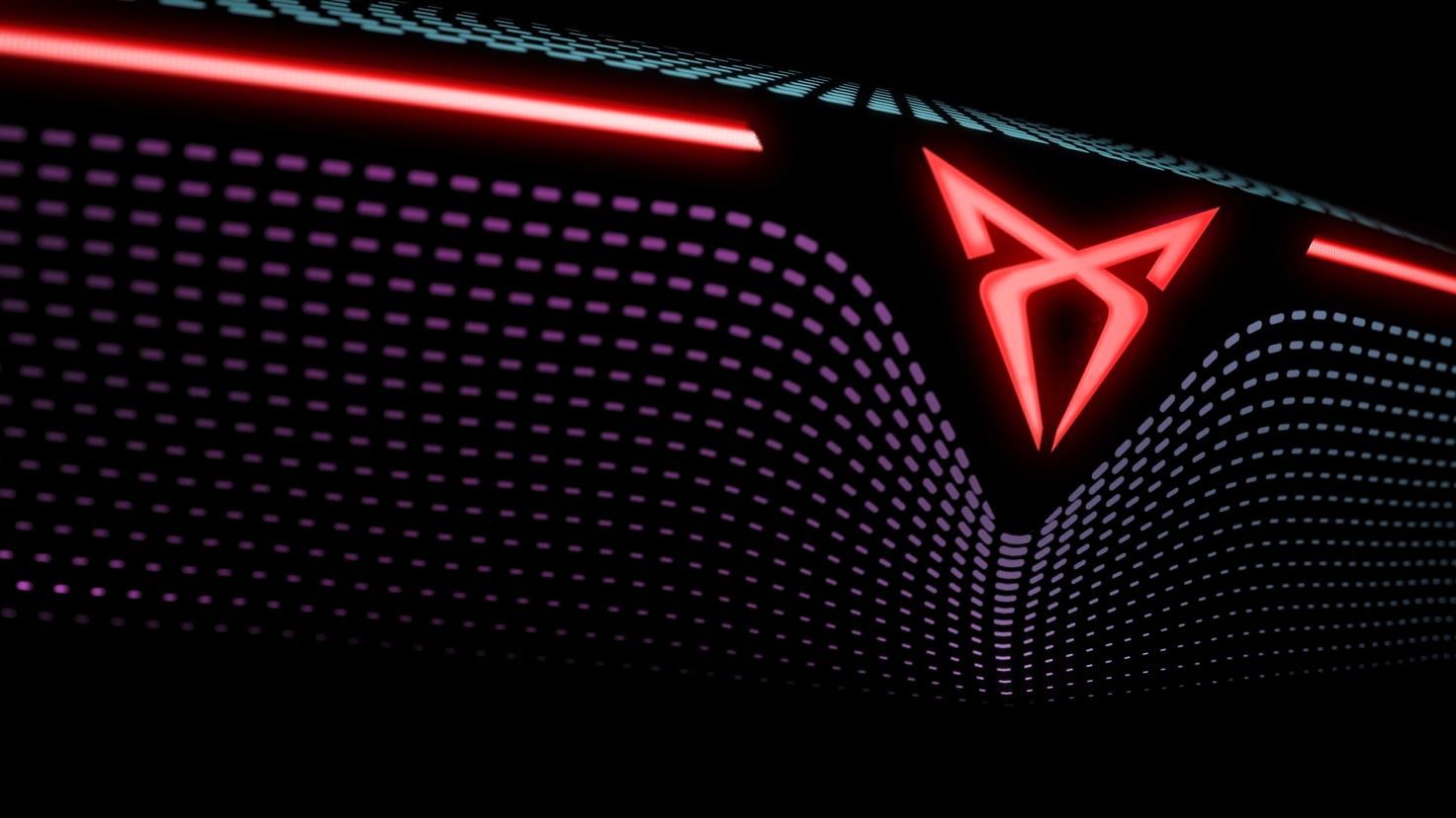 Futuristický detail vozidla so svetelným dizajnom zadných svetiel s logom CUPRA. Červené svetielka tvoria geometrické tvary na tmavom pozadí. Množstvo malých bodiek dodáva obrazu dynamický efekt.