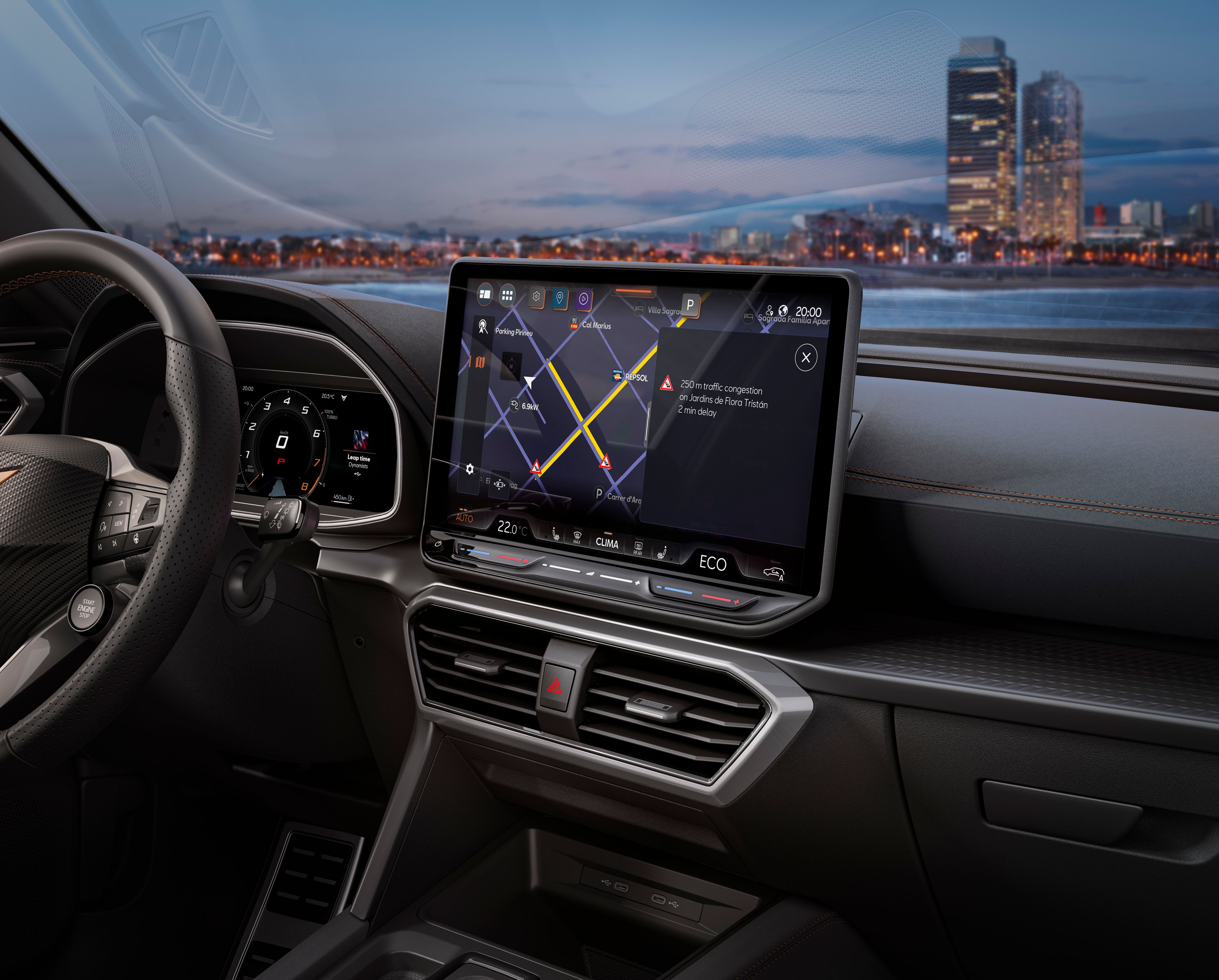 Interiér moderného automobilu s veľkým dotykovým displejom na palubnej doske. Na displeji je zobrazená mapa navigácie. V pozadí za oknom auta sú vidieť budovy mesta pri vode.