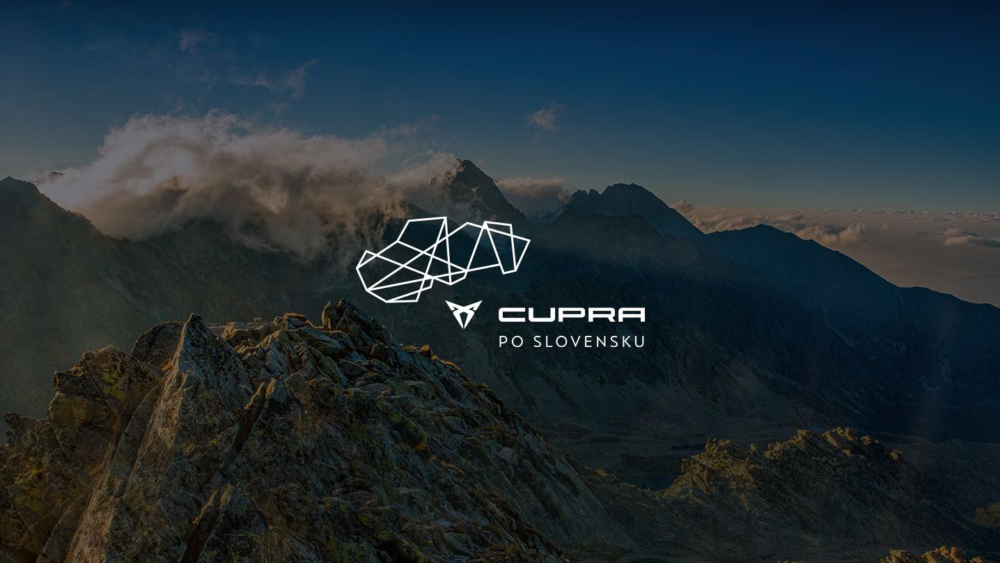 Pohľad na vysoké horské štíty a údolia počas západu slnka. V strede je logo značky CUPRA s nápisom "CUPRA PO SLOVENSKU". Scenéria zahŕňa skaly a vegetáciu osvetlenú zapadajúcim slnkom.