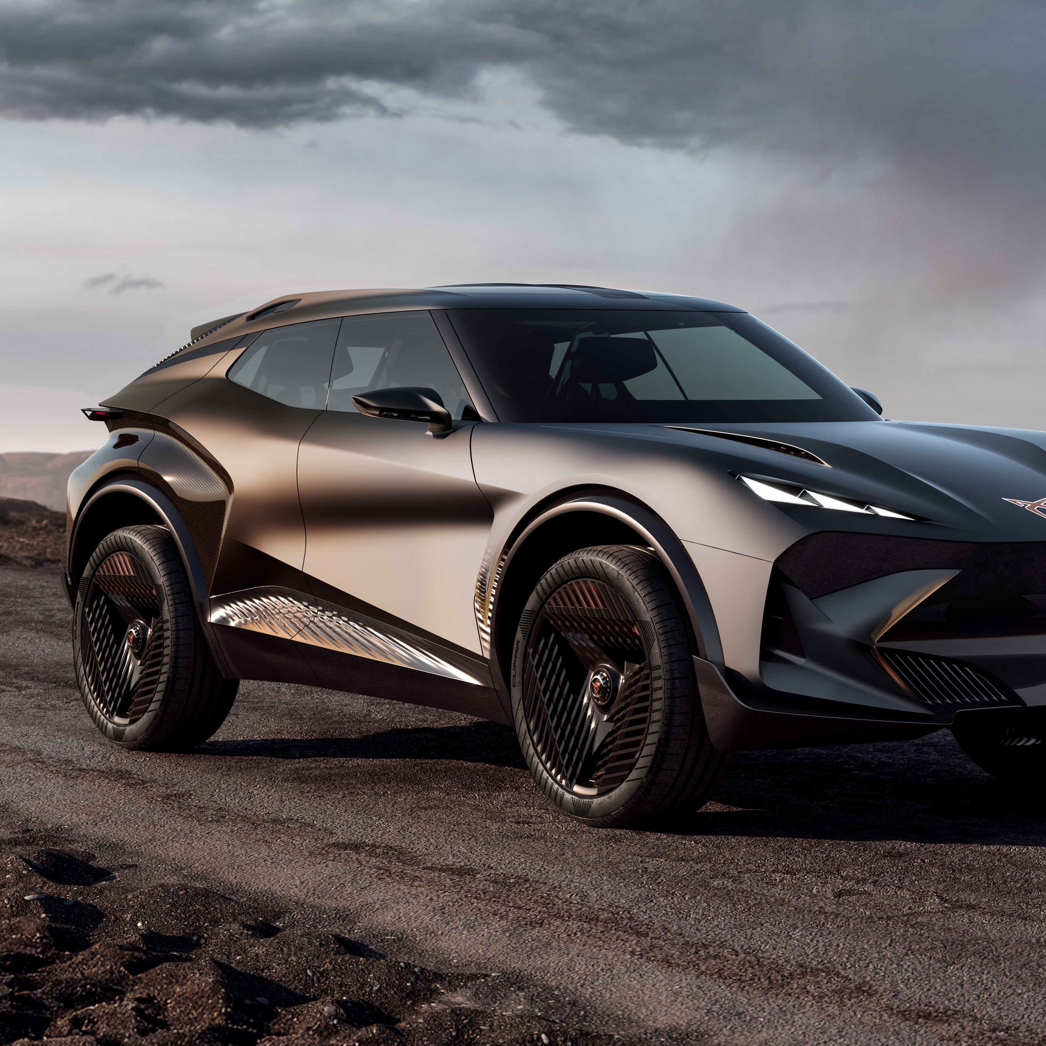 Moderné, športové SUV na prašnej ceste. Auto má zlato-čierny odtieň a futuristický dizajn. V pozadí sa nachádza priehľadný geometrický objekt a skalnatá krajina.