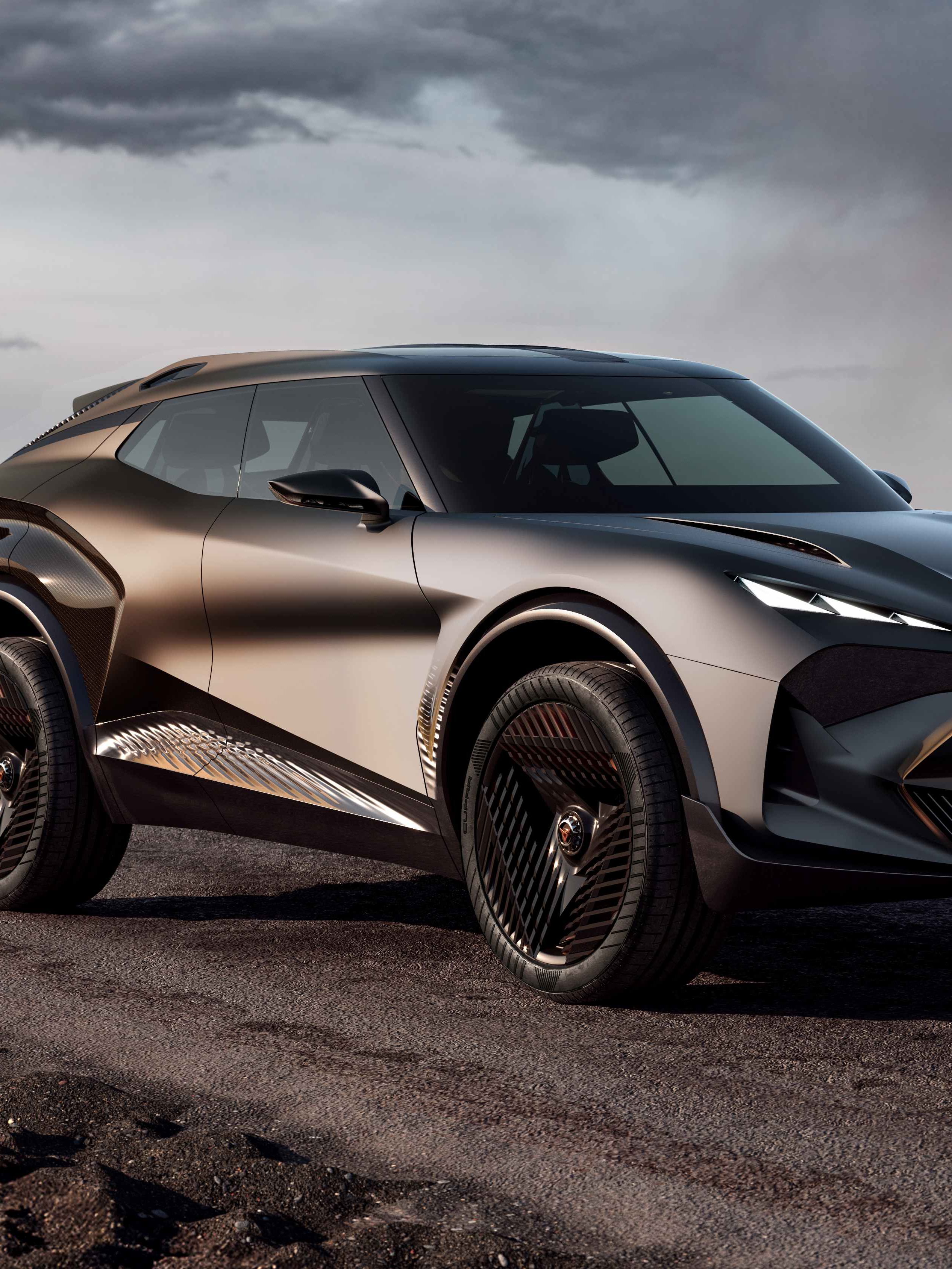 Moderné, športové SUV na prašnej ceste. Auto má zlato-čierny odtieň a futuristický dizajn. V pozadí sa nachádza priehľadný geometrický objekt a skalnatá krajina.