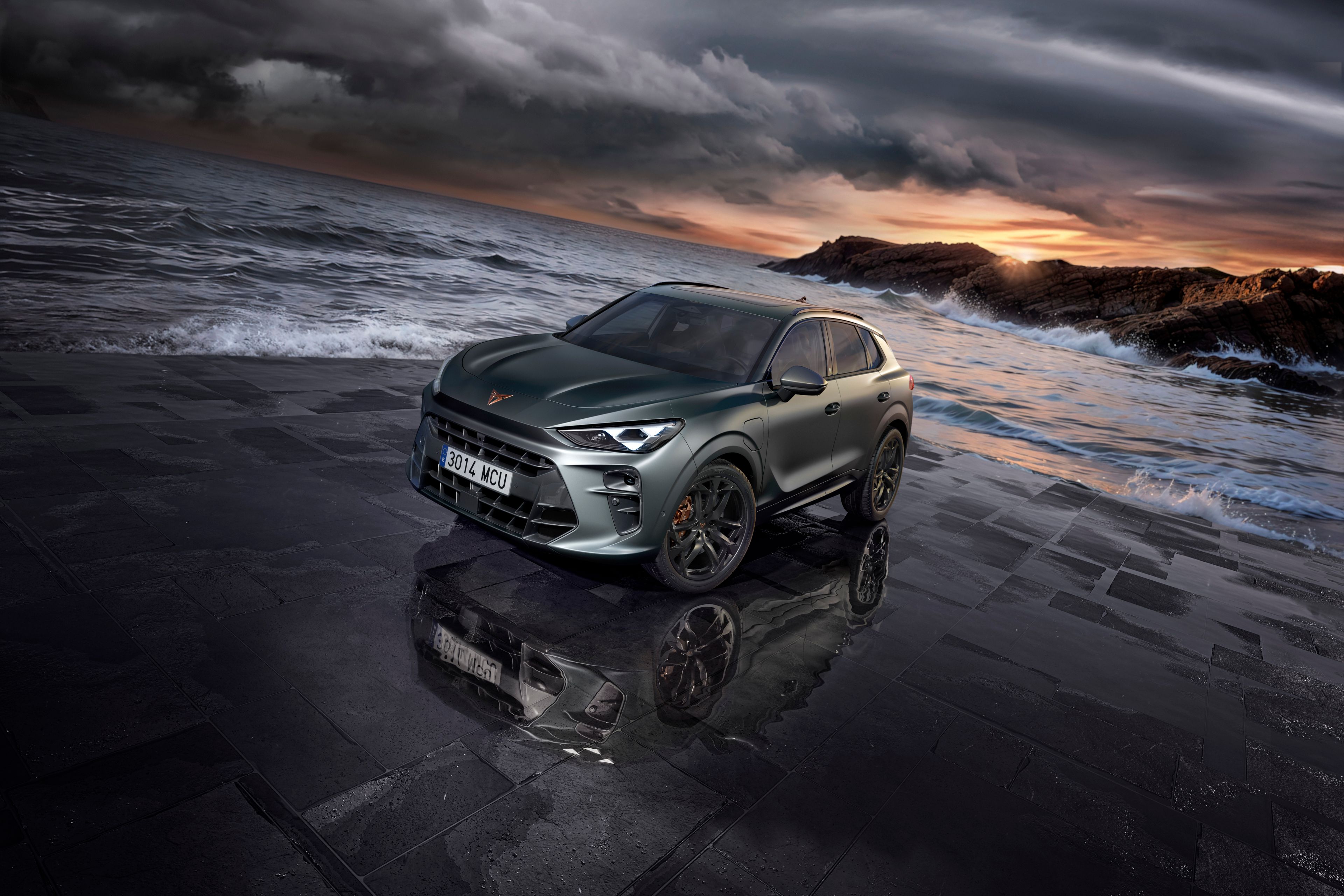 CUPRA Terramar zapakovaný na dláždenej ploche priamo pri mori. Vlny narážajú na na túto voľnú plochu. V pozadí sú skalné útesy