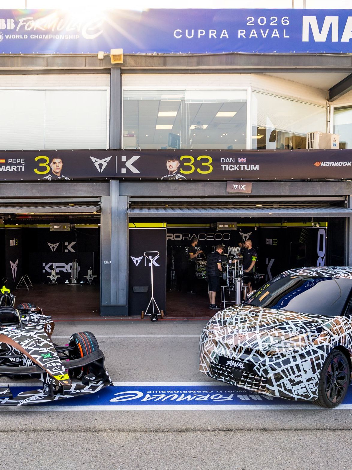 CUPRA Raval a Formula E zaparkované pred tímovými boxami. 