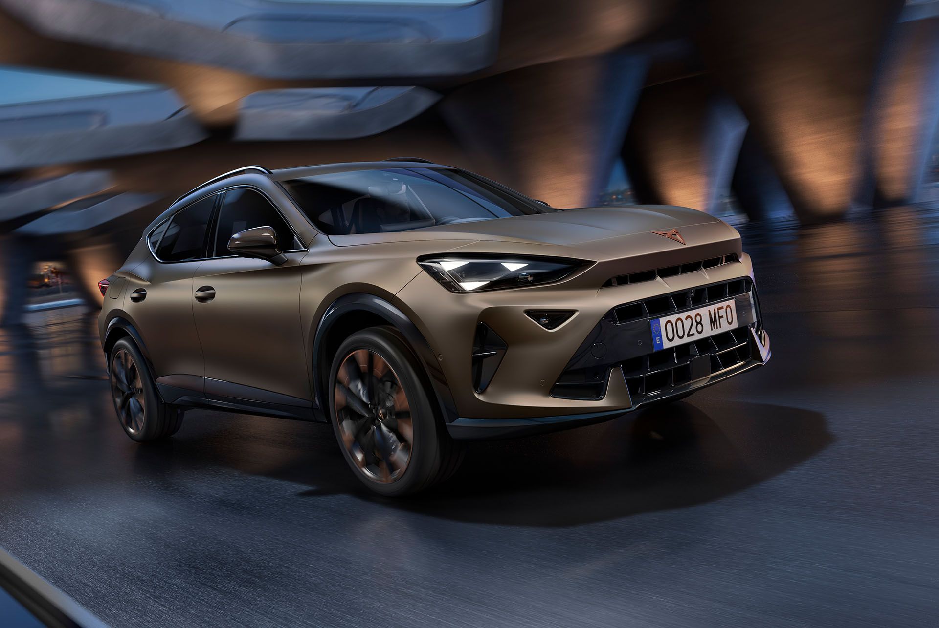Moderné SUV Cupra Formentor jazdí vysokou rýchlosťou po osvetlenej ceste v mestskom prostredí. Má dynamický a športový dizajn.