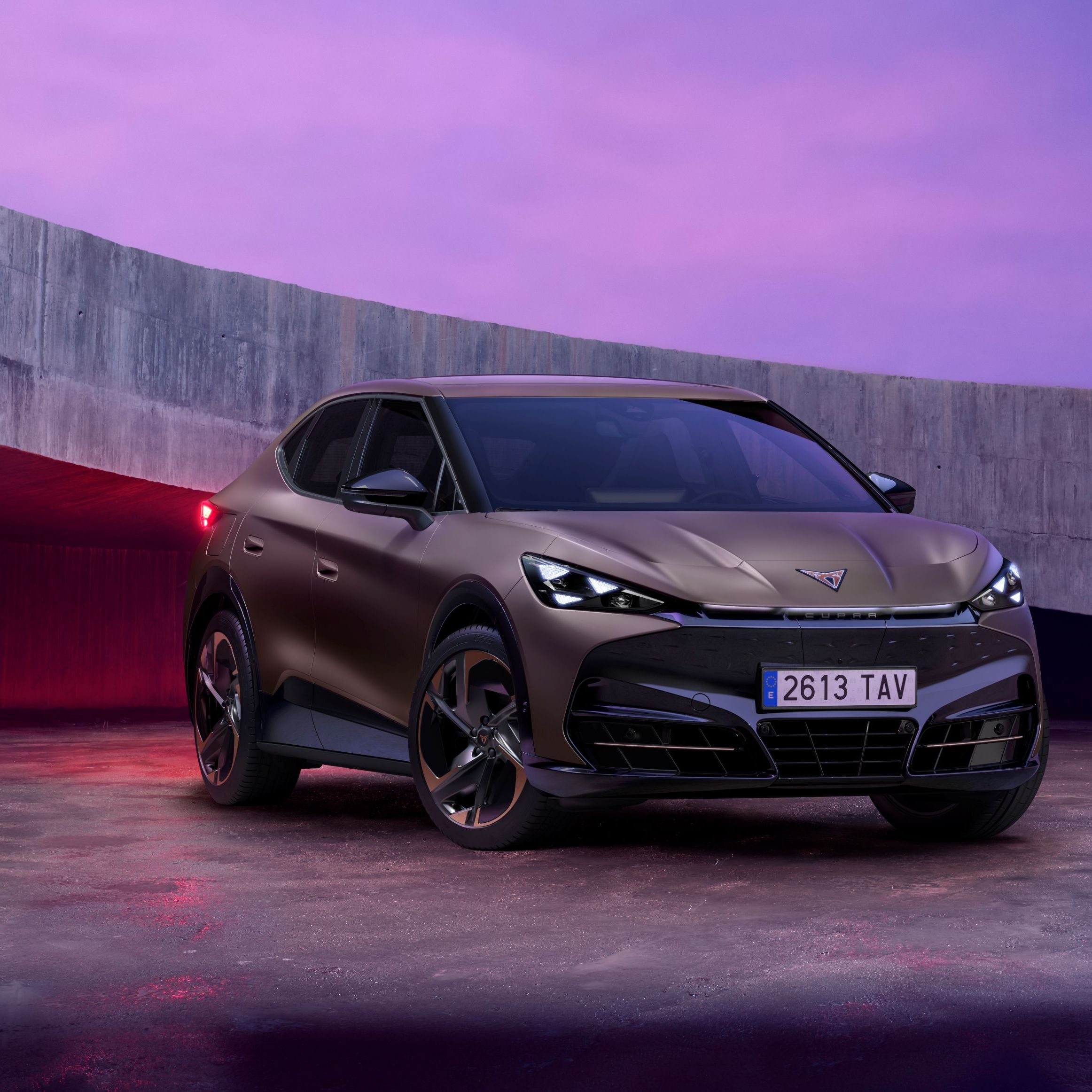 CUPRA Tavadcan zaparkovaný na betónovej ploche vedľa betónovej lávky. Obrázok dotvára ružový filter. 