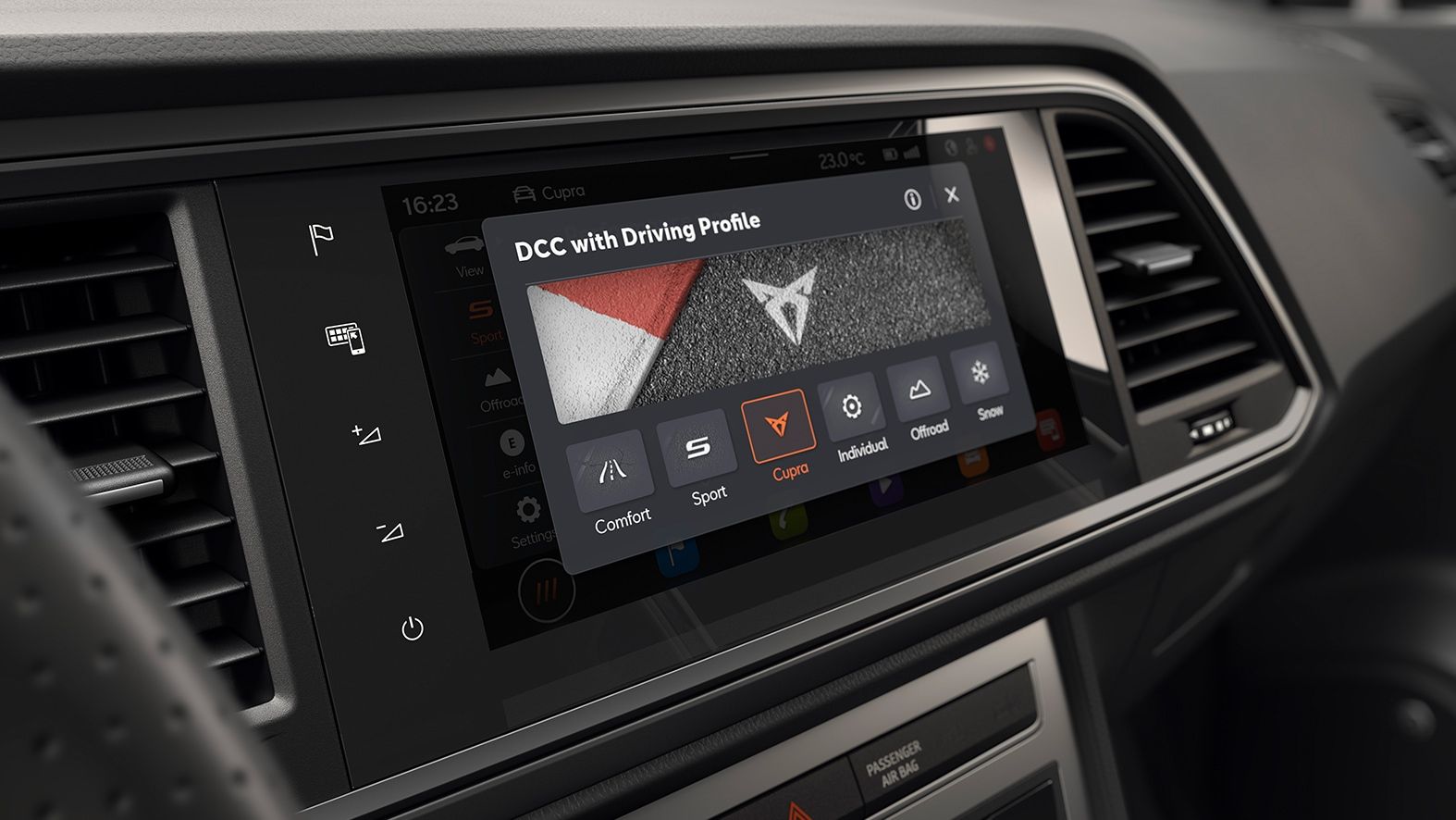 Palubná doska automobilu s integrovaným digitálnym displejom systému infotainment. Na displeji sú rôzne jazdné režimy vrátane športového a komfortného. Ovládacie prvky dotykovej obrazovky sú jasne viditeľné.