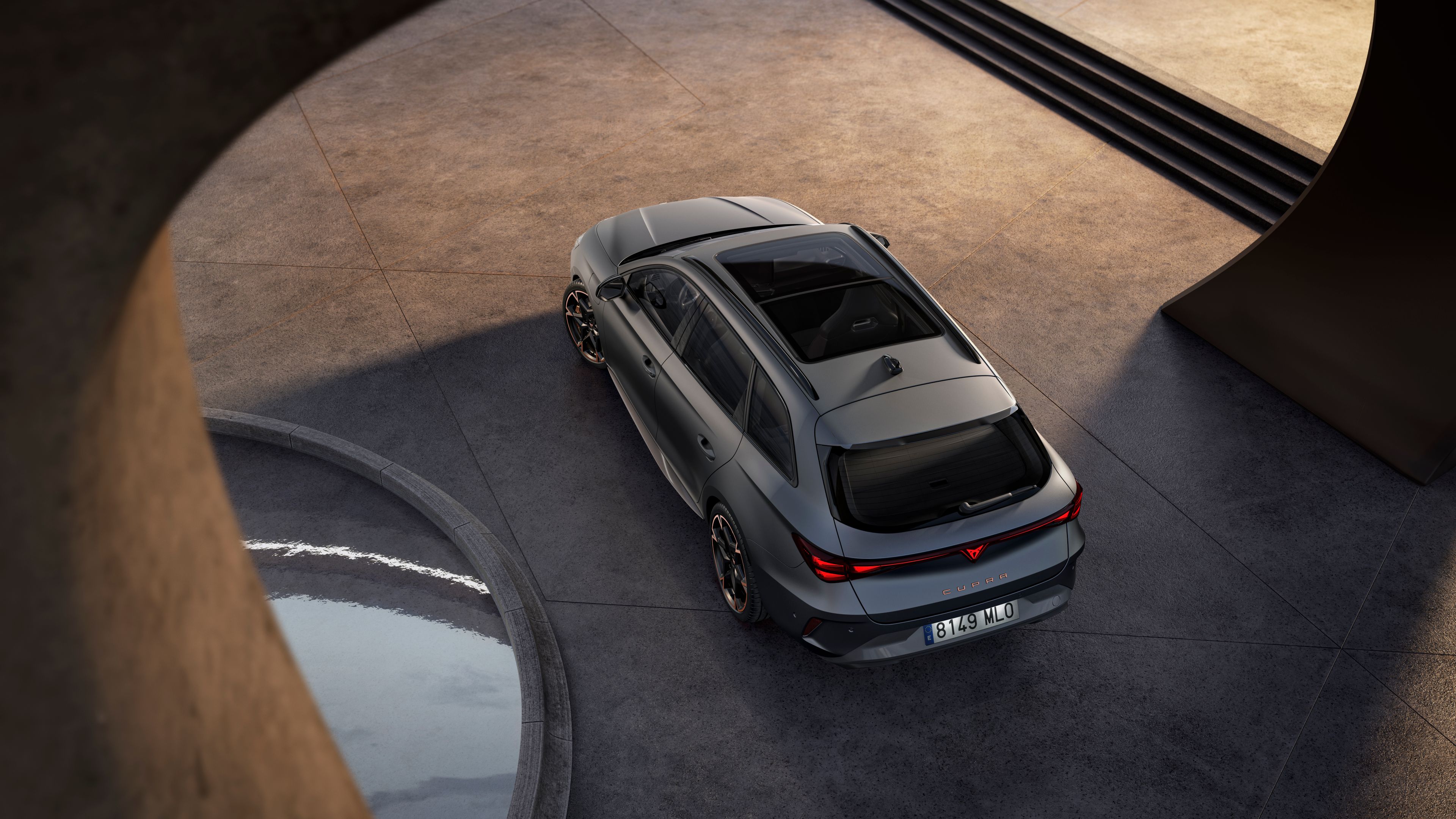 CUPRA Leon Sportstourer na voľnej dláždenej ploche pri modernej budove.