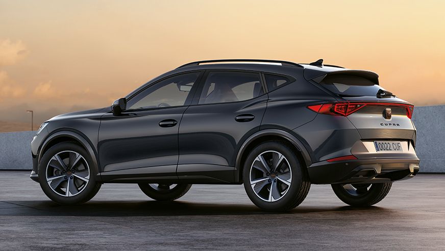 Sivý CUPRA Formentor zaparkovaný von. Okolie je osvetlené zapadajúcim slnkom.