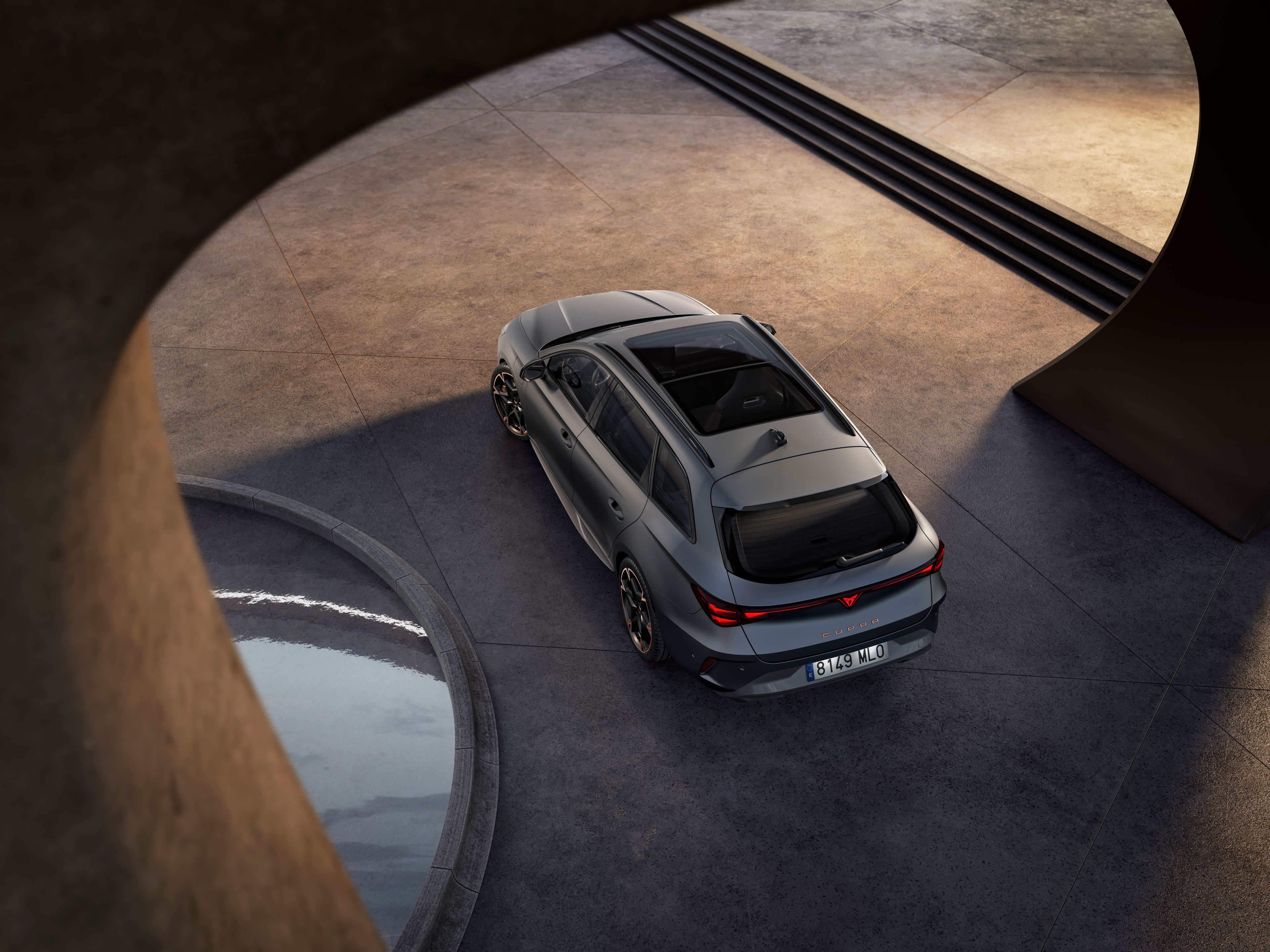 CUPRA Leon Sportstourer na voľnej dláždenej ploche pri modernej budove.