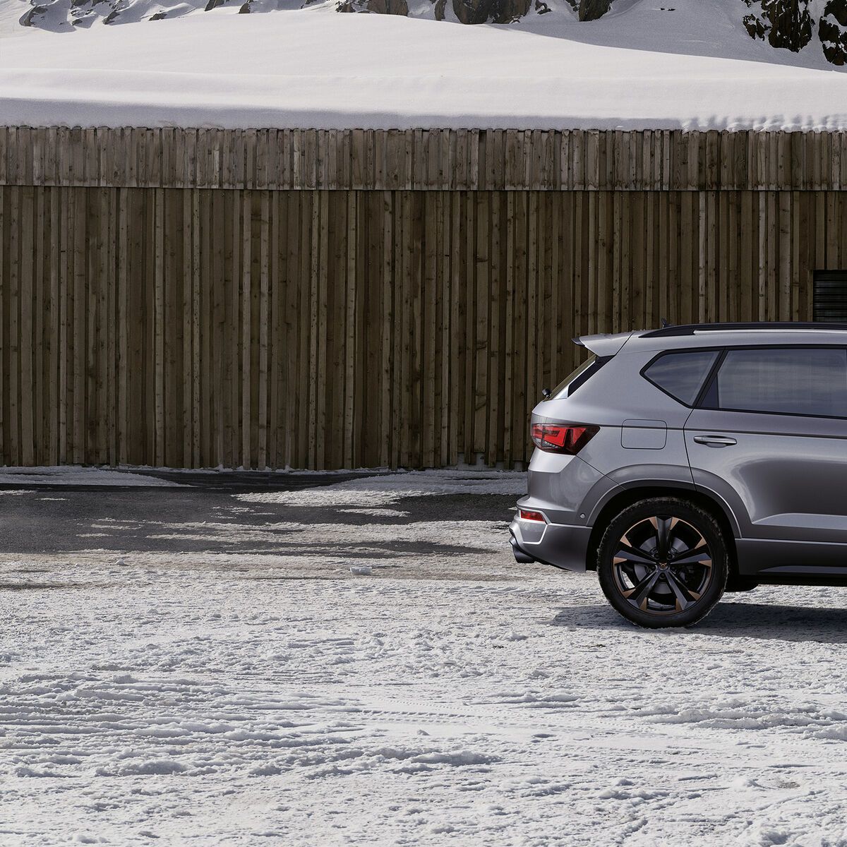 Ein CUPRA Ateca in grau, eine Frau steht davor