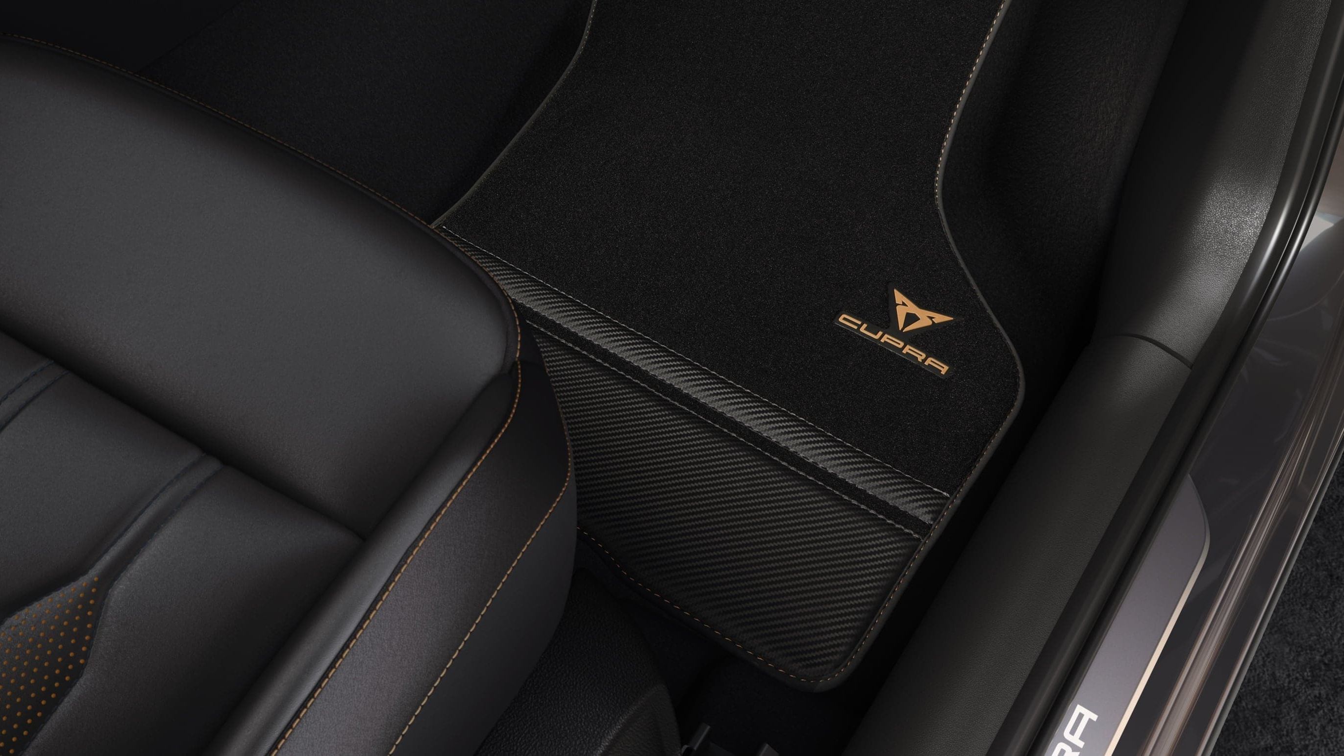 Detailný záber na čierne sedadlá a koberček s logom CUPRA. 